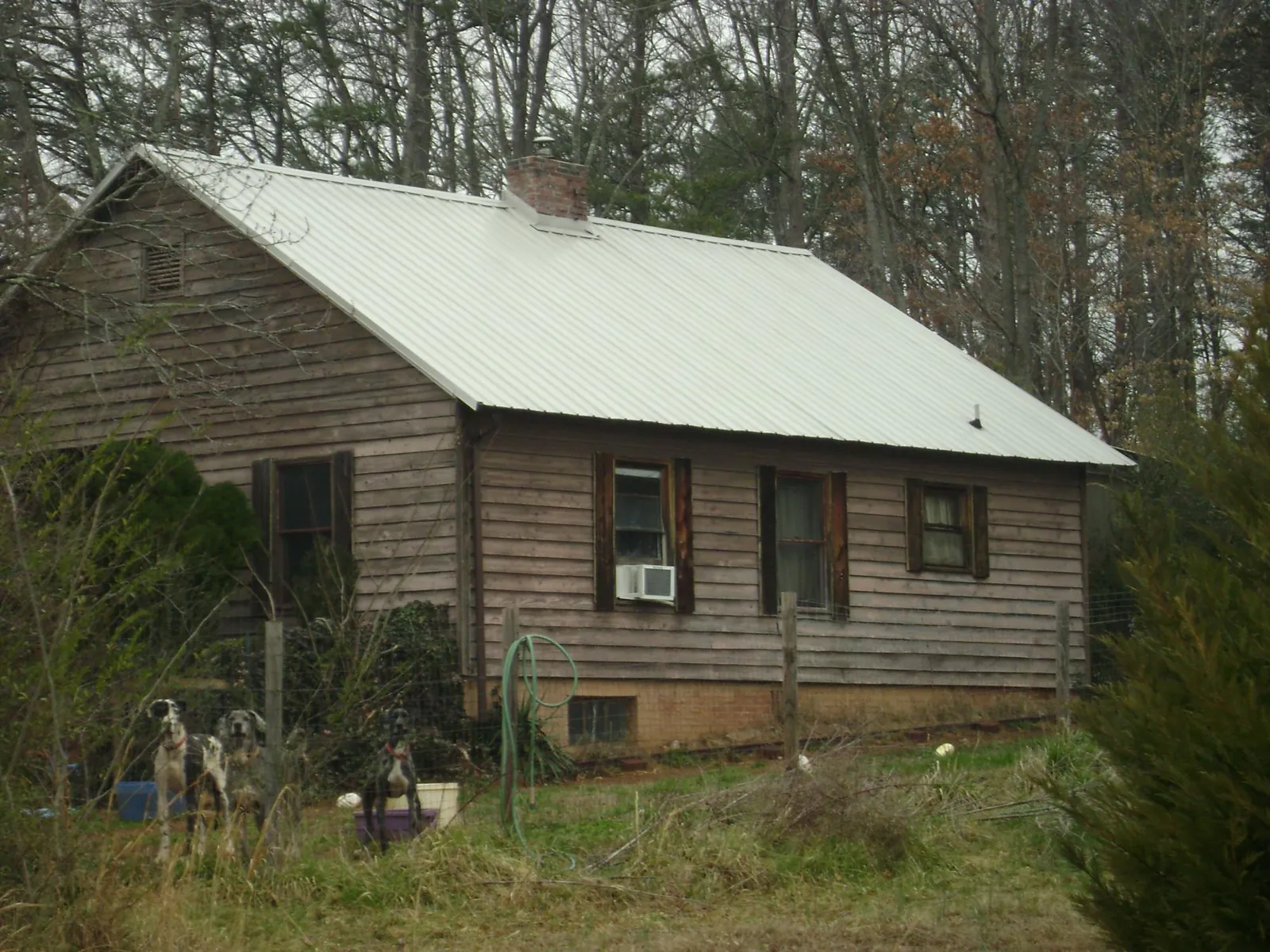 White metal roof on an old wood sided farmhouse, from a Asphalt Shingle Roof Repair job in Garnett